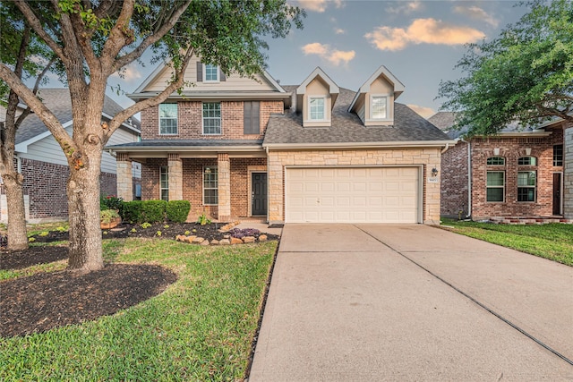 view of front of home with roof with shingles, a front yard, concrete driveway, an attached garage, and stone siding