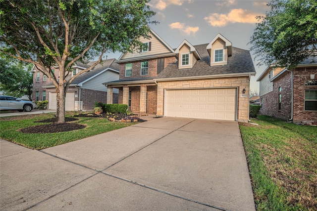 view of front of home with a garage, a front lawn, roof with shingles, brick siding, and driveway