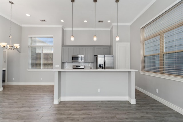 kitchen with visible vents, appliances with stainless steel finishes, gray cabinetry, an inviting chandelier, and ornamental molding