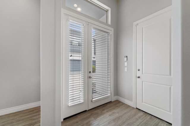 doorway to outside with baseboards, french doors, and light wood-style flooring