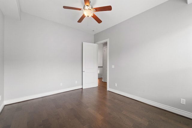 unfurnished room with baseboards, dark wood finished floors, ceiling fan, and radiator