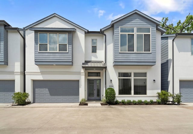townhome / multi-family property with a garage, stucco siding, and driveway