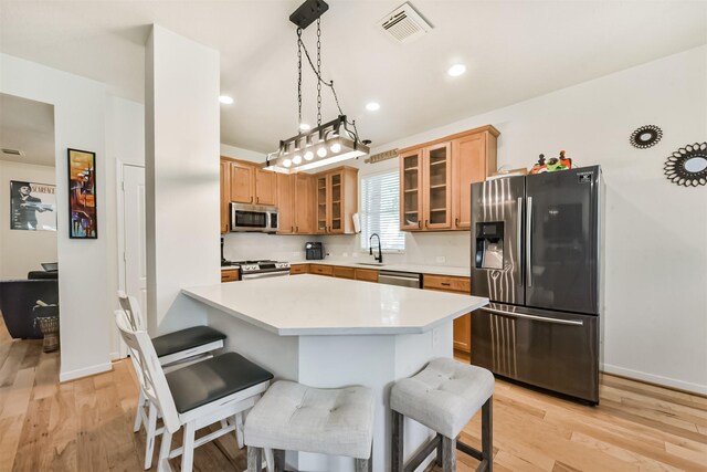 18307 Wild Lilac Trl, Humble, TX 77346 - kitchen with light countertops, stainless steel appliances, a kitchen bar, and visible vents