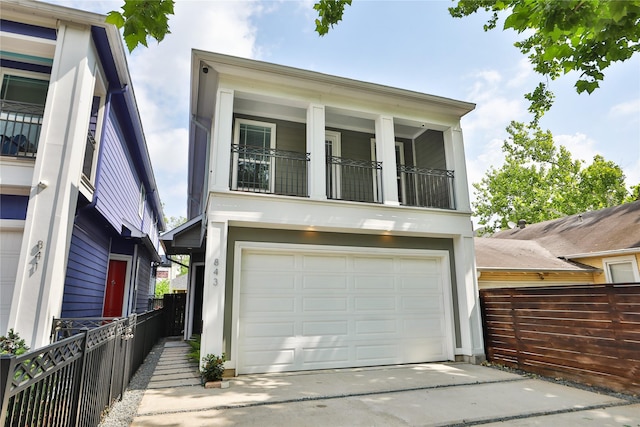 view of front of house with driveway, fence, a balcony, and a garage