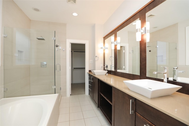 bathroom featuring a garden tub, a sink, tile patterned flooring, and a shower stall