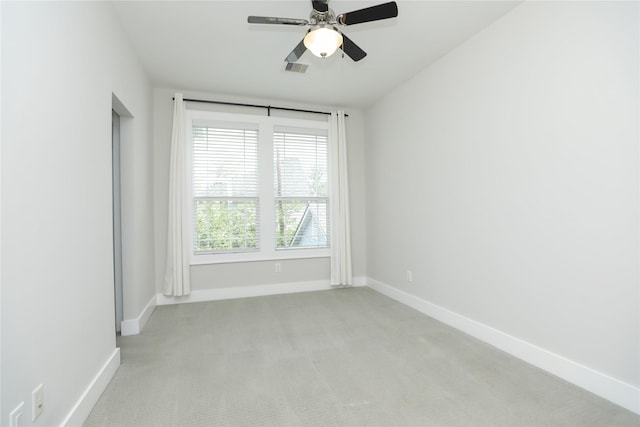 empty room featuring baseboards, visible vents, a ceiling fan, and light colored carpet