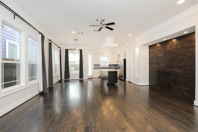 unfurnished living room with ornamental molding, baseboards, ceiling fan, dark wood-type flooring, and recessed lighting