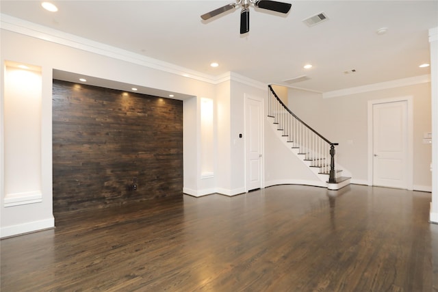 unfurnished living room featuring ceiling fan, visible vents, wood finished floors, stairway, and ornamental molding