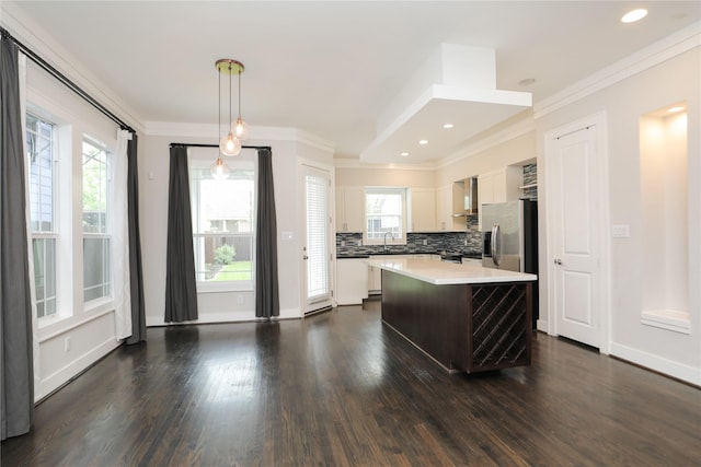 kitchen featuring crown molding, light countertops, white cabinets, and a center island