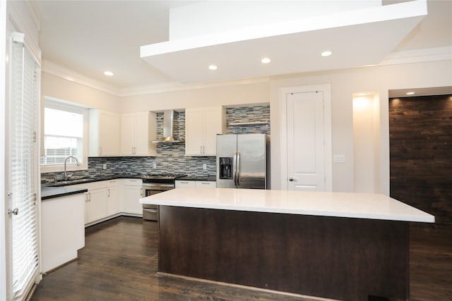 kitchen with ornamental molding, a kitchen island, a sink, backsplash, and stainless steel appliances