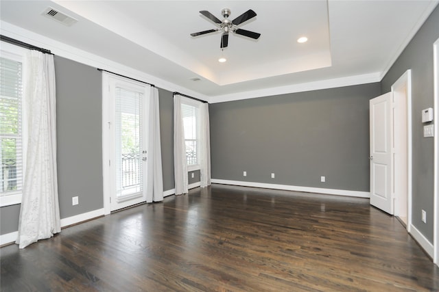 unfurnished room featuring a ceiling fan, baseboards, visible vents, and wood finished floors