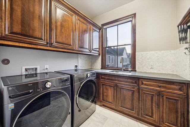 washroom with a sink, separate washer and dryer, cabinet space, and marble finish floor
