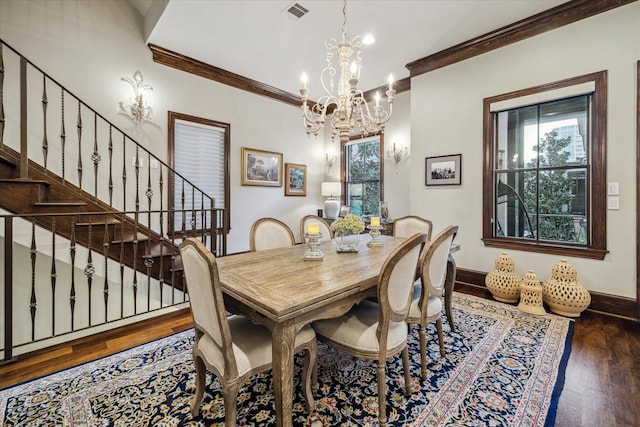 dining room featuring crown molding, visible vents, an inviting chandelier, and wood finished floors