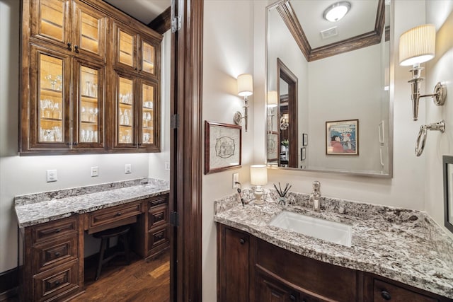 bathroom with crown molding, visible vents, wood finished floors, and vanity