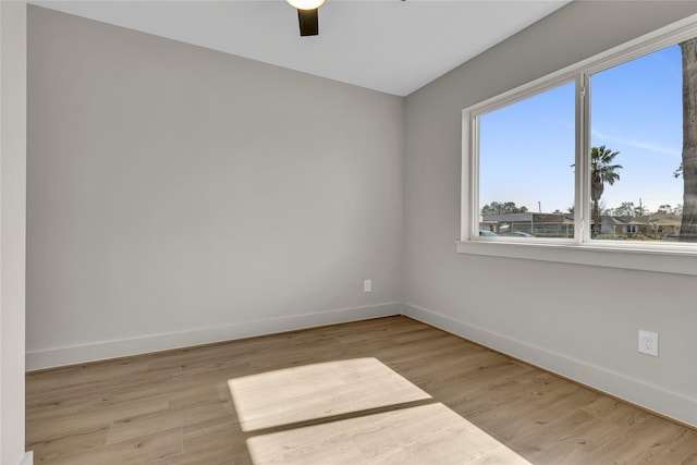 empty room with baseboards, ceiling fan, and wood finished floors