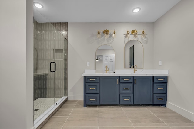 bathroom featuring tile patterned floors, a shower stall, baseboards, and vanity