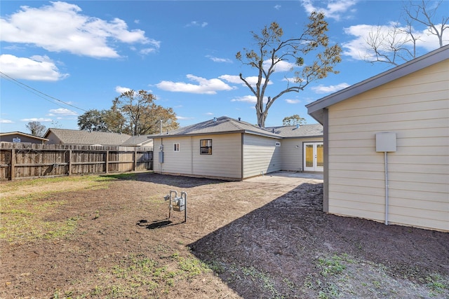 rear view of property featuring french doors and fence