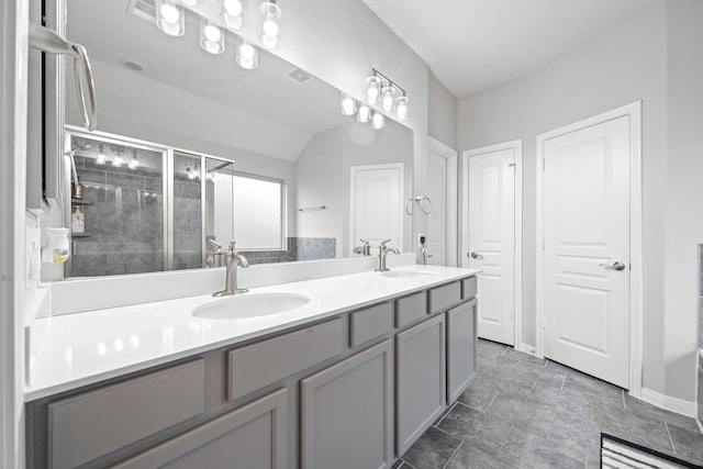 full bathroom featuring double vanity, baseboards, a sink, and a stall shower