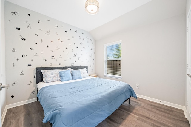 bedroom with baseboards, wood finished floors, and lofted ceiling