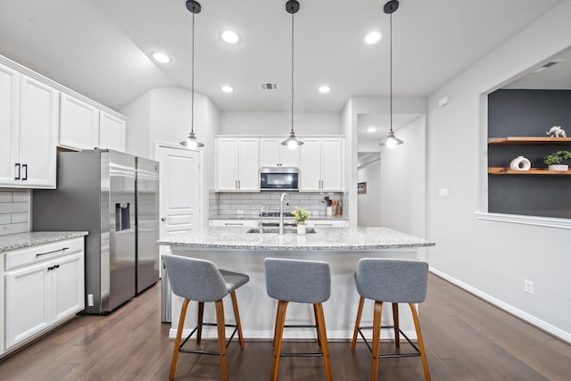 kitchen with visible vents, a sink, dark wood-style floors, stainless steel appliances, and white cabinetry