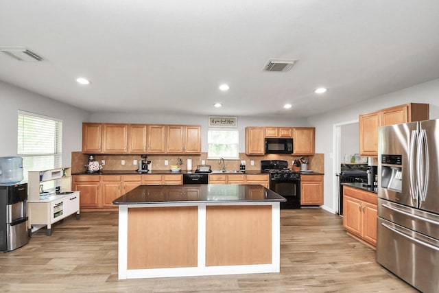 15519 Hensen Creek Dr, Houston, TX 77086 - kitchen featuring black appliances, a sink, dark countertops, a kitchen island, and recessed lighting