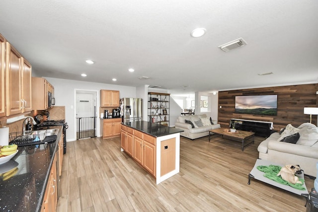 15519 Hensen Creek Dr, Houston, TX 77086 - kitchen featuring stainless steel refrigerator with ice dispenser, open floor plan, a kitchen island, light brown cabinetry, and light wood-style flooring
