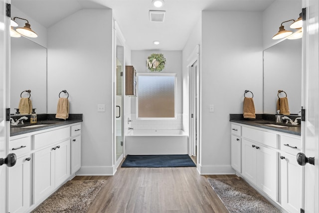 bathroom with two vanities, a sink, and wood finished floors