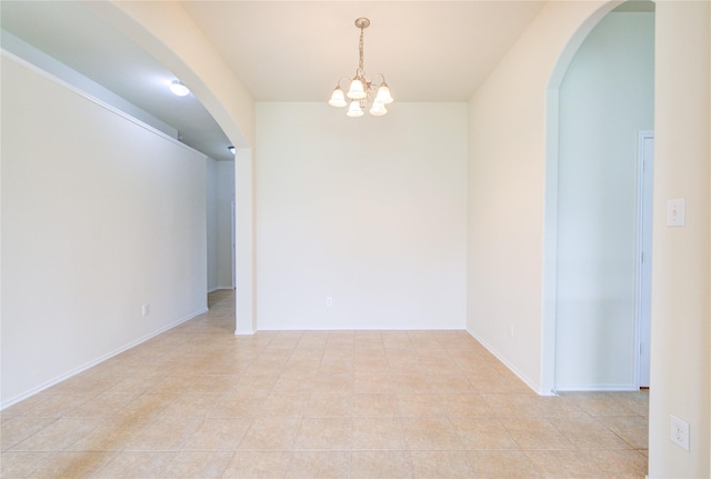 spare room with arched walkways, baseboards, a notable chandelier, and light tile patterned floors