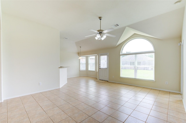 unfurnished room with a ceiling fan, visible vents, vaulted ceiling, light tile patterned floors, and baseboards