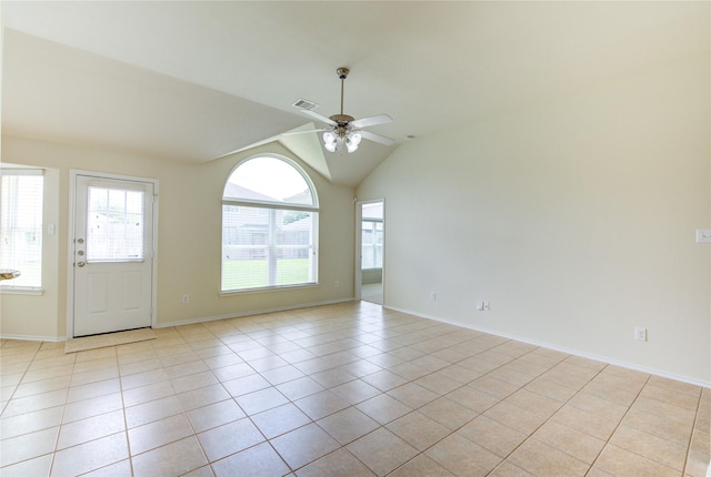 spare room with visible vents, lofted ceiling, light tile patterned flooring, baseboards, and ceiling fan