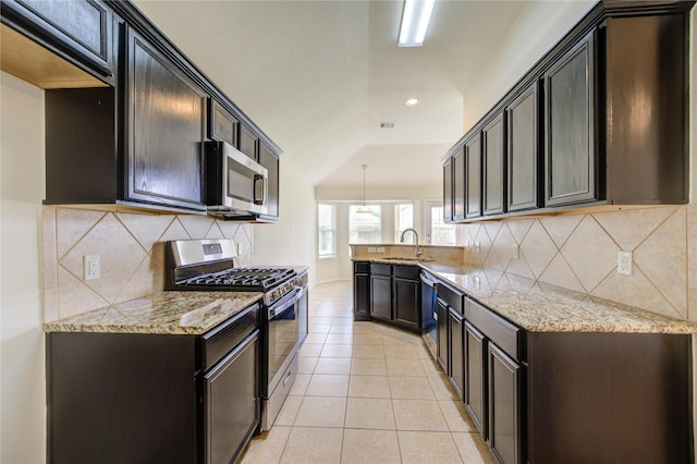kitchen with light stone counters, a sink, a peninsula, and stainless steel appliances