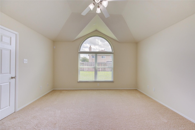 empty room with baseboards, ceiling fan, vaulted ceiling, and light colored carpet