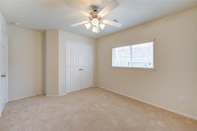 unfurnished bedroom featuring a ceiling fan, baseboards, carpet, and a closet