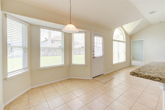 entryway with visible vents, vaulted ceiling, light tile patterned flooring, and a wealth of natural light