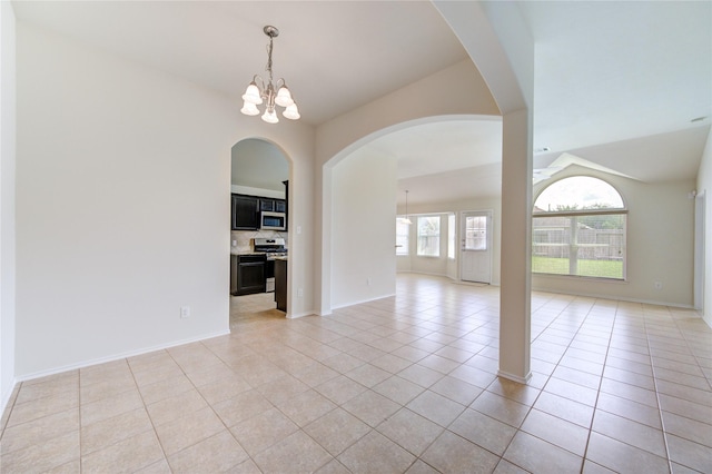 unfurnished room with baseboards, a notable chandelier, light tile patterned floors, and vaulted ceiling
