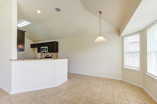 kitchen with light stone countertops, appliances with stainless steel finishes, visible vents, vaulted ceiling, and pendant lighting