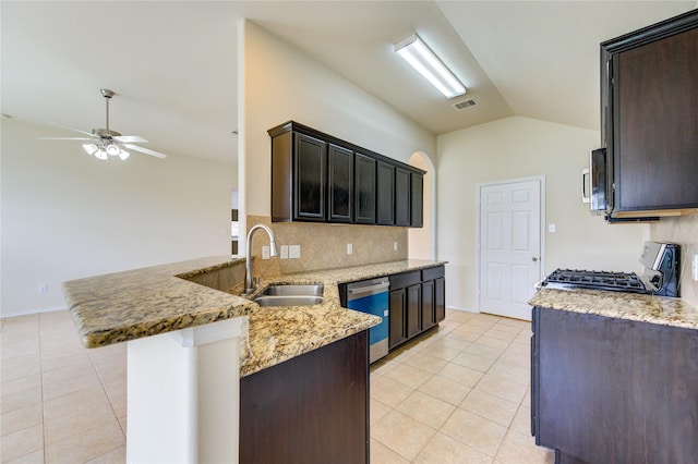 kitchen featuring a sink, stainless steel appliances, a peninsula, light tile patterned floors, and vaulted ceiling