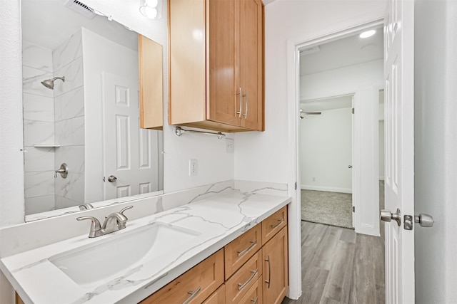 bathroom with vanity, walk in shower, and wood finished floors