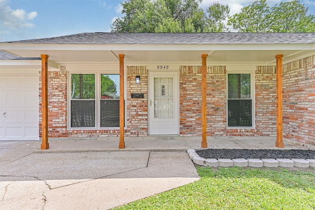 property entrance with covered porch, a shingled roof, an attached garage, and brick siding
