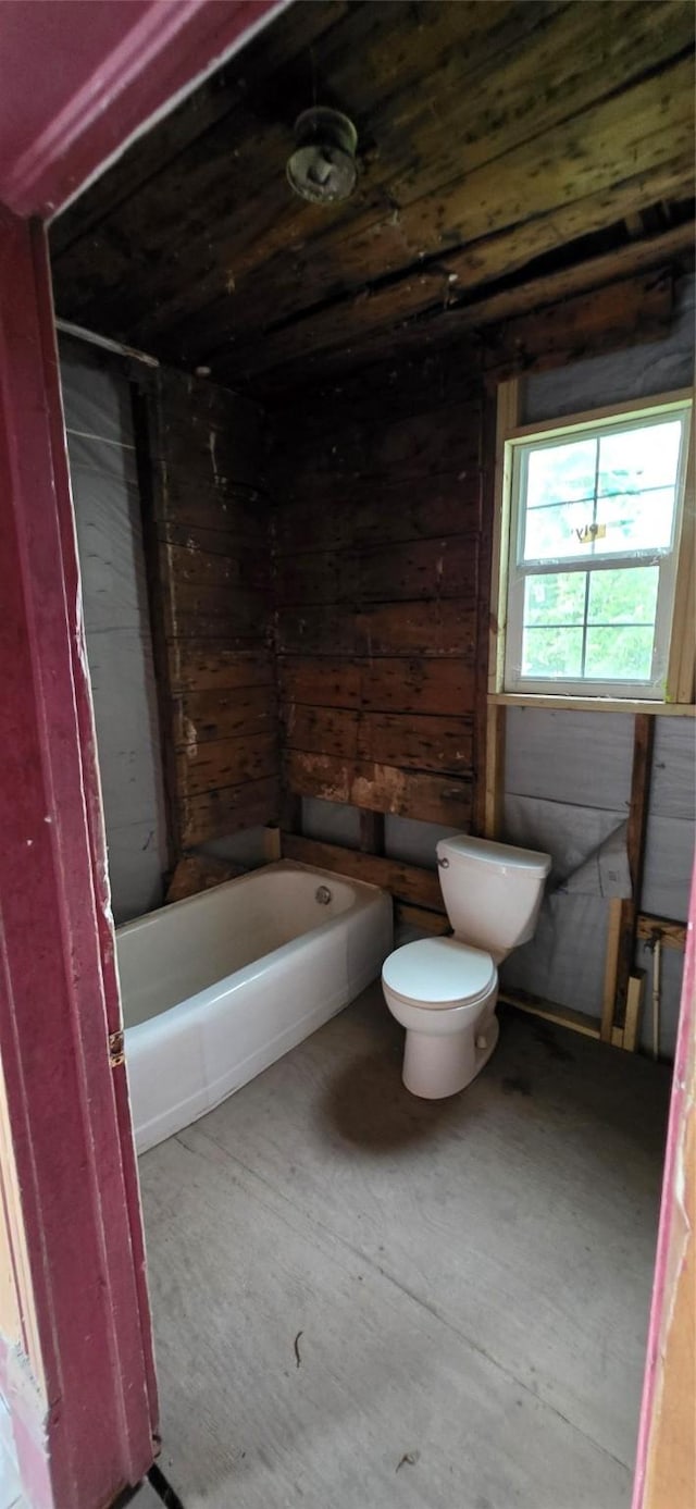 1426 E 36th St, Houston, TX 77022 - full bathroom with wooden walls, toilet, and shower / bath combination