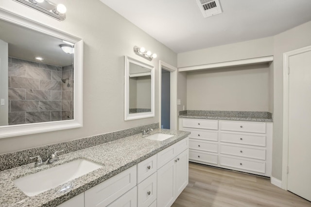 6531 Coral Ridge Rd, Houston, TX 77069 - full bath featuring double vanity, visible vents, a sink, and wood finished floors
