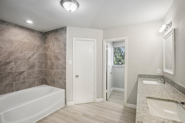 6531 Coral Ridge Rd, Houston, TX 77069 - bathroom featuring a bathing tub, double vanity, a sink, and wood finished floors