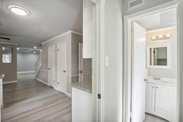 6531 Coral Ridge Rd, Houston, TX 77069 - hall featuring a sink, baseboards, light wood-type flooring, visible vents, and stairway