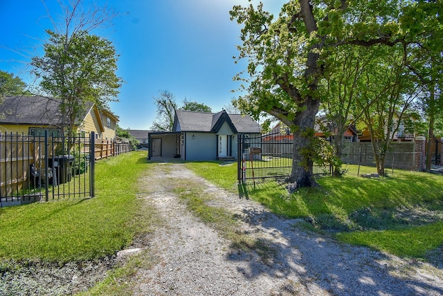 view of front facade with fence private yard, a front lawn, and driveway