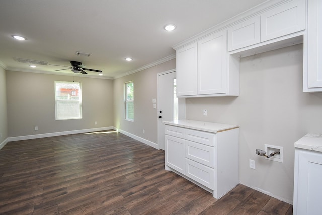 interior space with ornamental molding, a ceiling fan, white cabinetry, visible vents, and dark wood-style floors