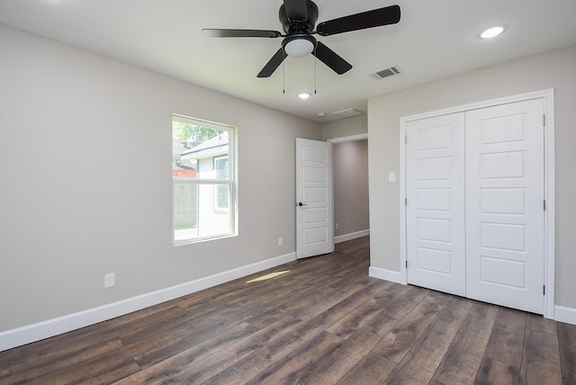unfurnished bedroom with baseboards, dark wood-style floors, and visible vents