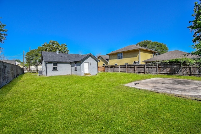 back of house featuring a yard, central AC, a fenced backyard, and a patio area