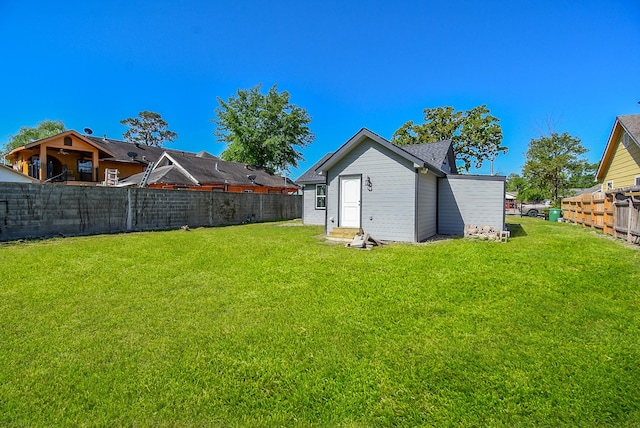 back of property featuring a yard and a fenced backyard