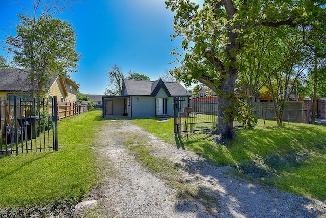 exterior space featuring a lawn, a gate, driveway, and fence private yard