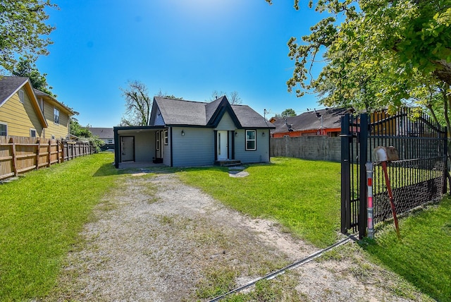 rear view of house featuring a lawn, a gate, and a fenced backyard